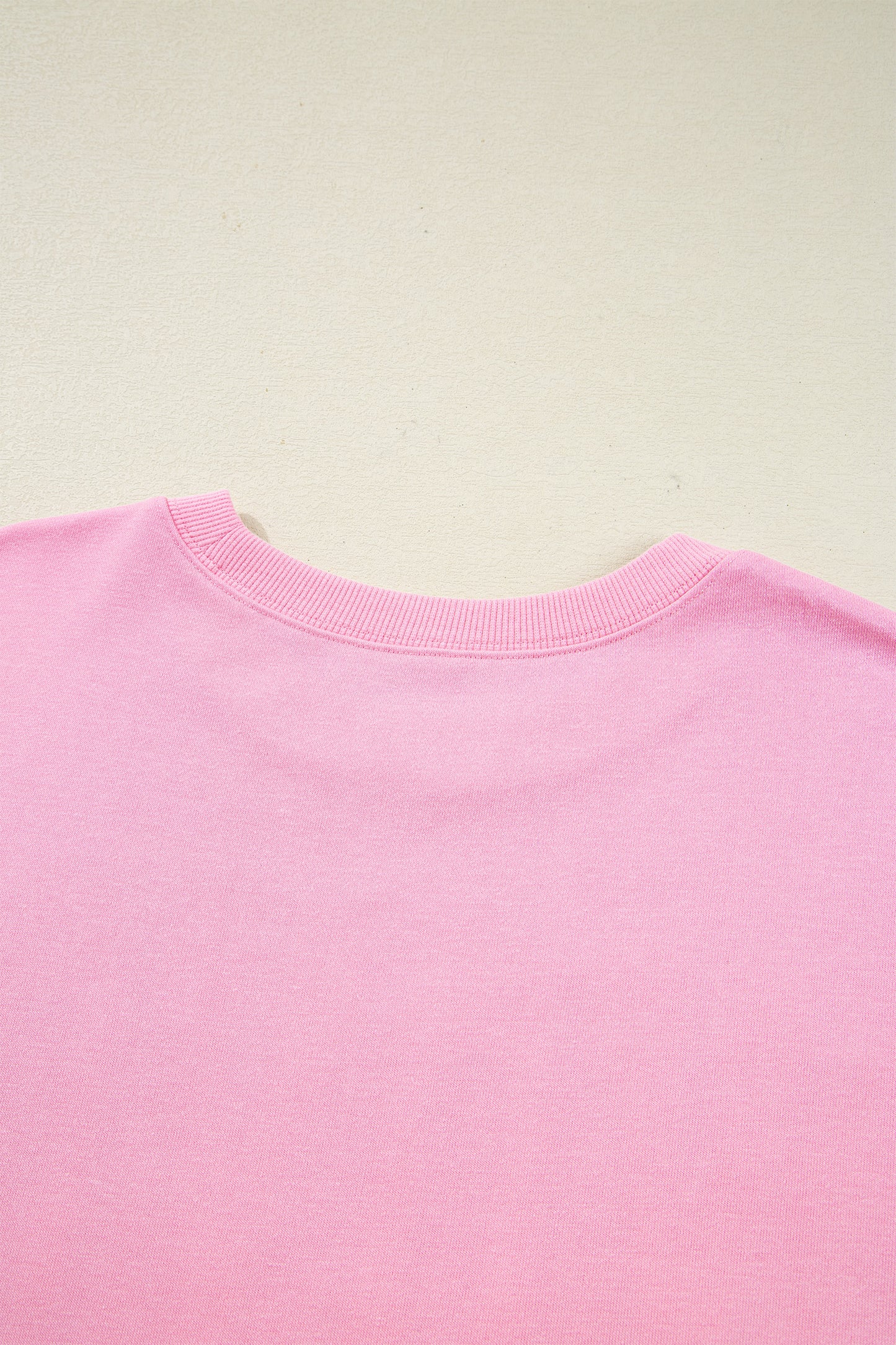 Pink bow sequin XOXO letter graphic baggy sweatshirt by Lavendar Lane Clothing, featuring exposed seams and casual blouse style.