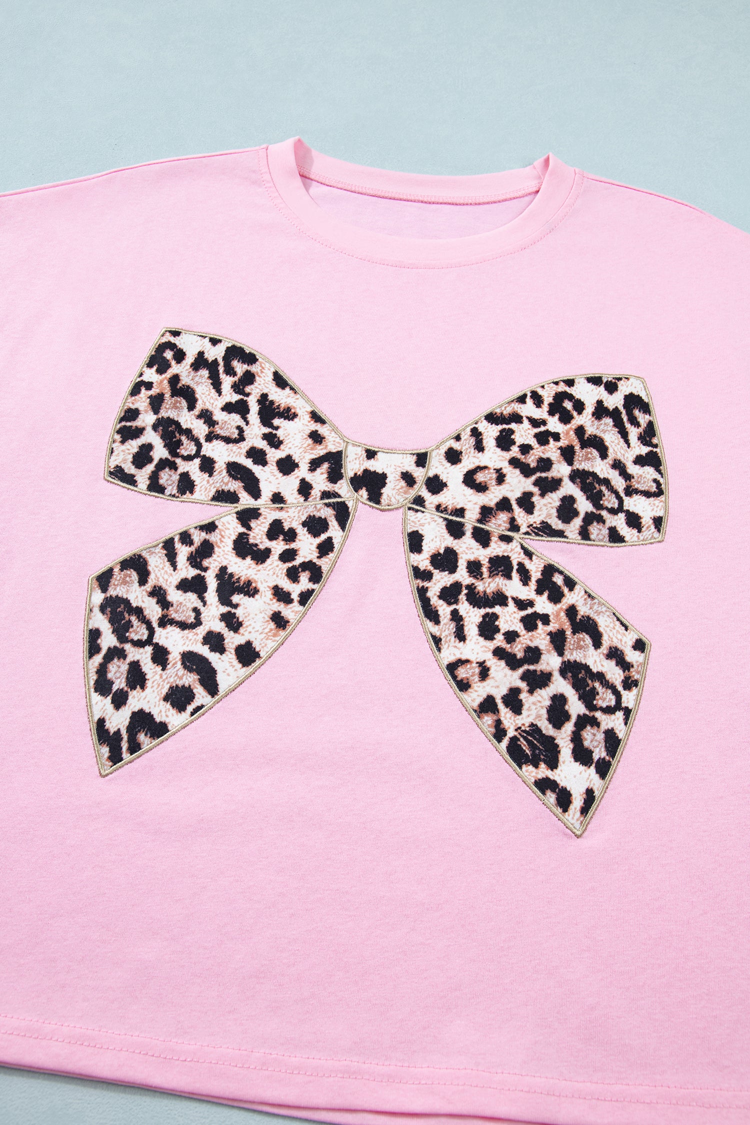 Pink leopard bow embroidered cotton round neck T-shirt from Lavendar Lane Clothing, featuring a playful animal print and bow detail.