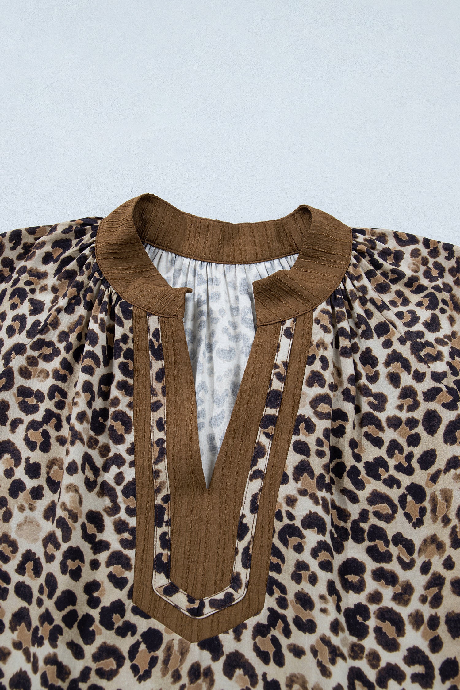 Plus size brown leopard print crinkled colorblock V-neck blouse by Lavendar Lane Clothing, featuring patchwork design and long sleeves.