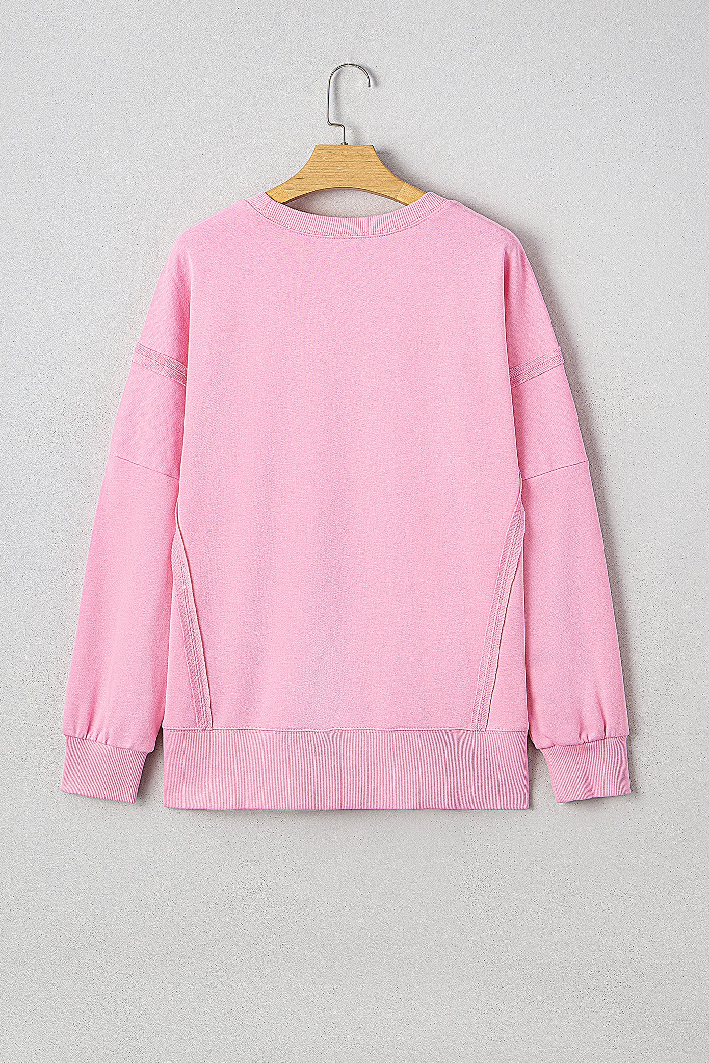 Pink sequin XOXO letter graphic baggy sweatshirt with exposed seams from Lavendar Lane Clothing, featuring a bow design.