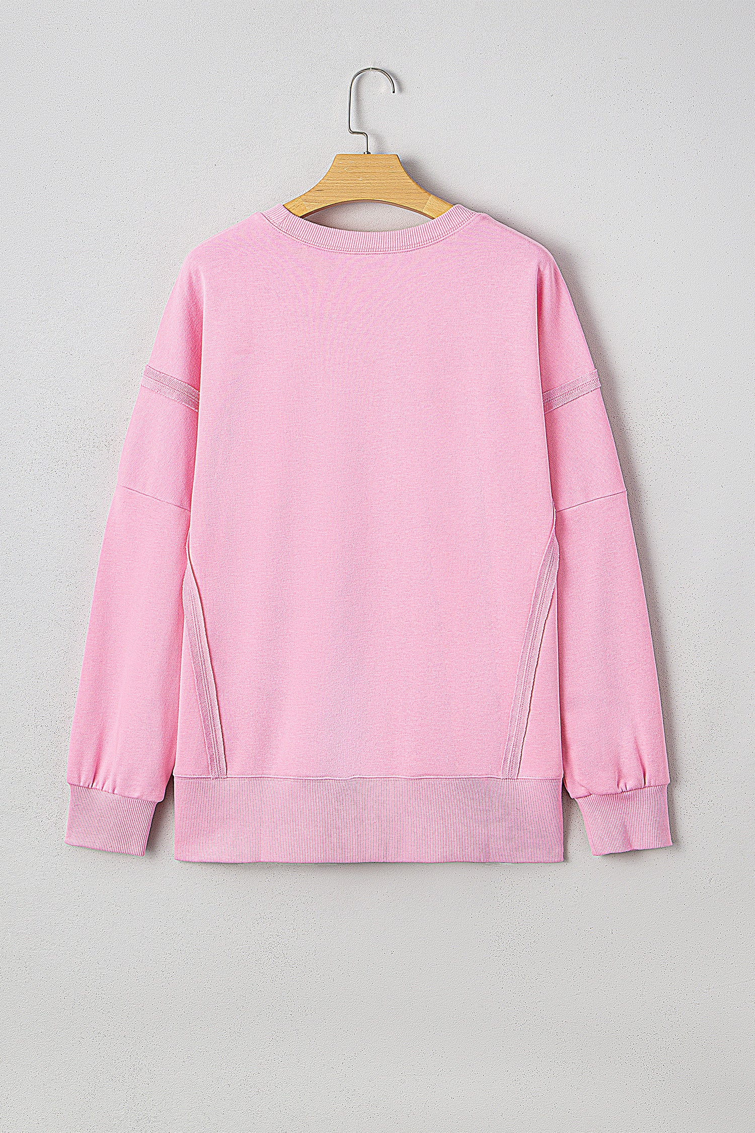 Pink sequin XOXO letter graphic baggy sweatshirt with exposed seams from Lavendar Lane Clothing, featuring a bow design.