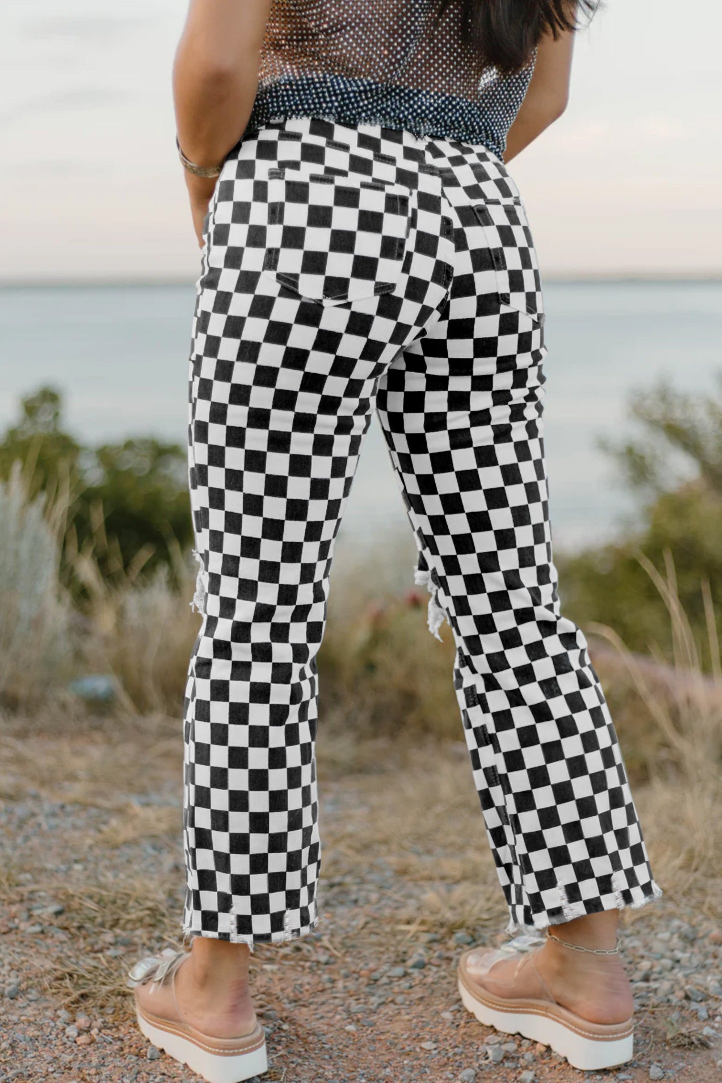 Black checkerboard print distressed raw edge cropped jeans by Lavendar Lane Clothing, showcasing frayed hems and ripped details.