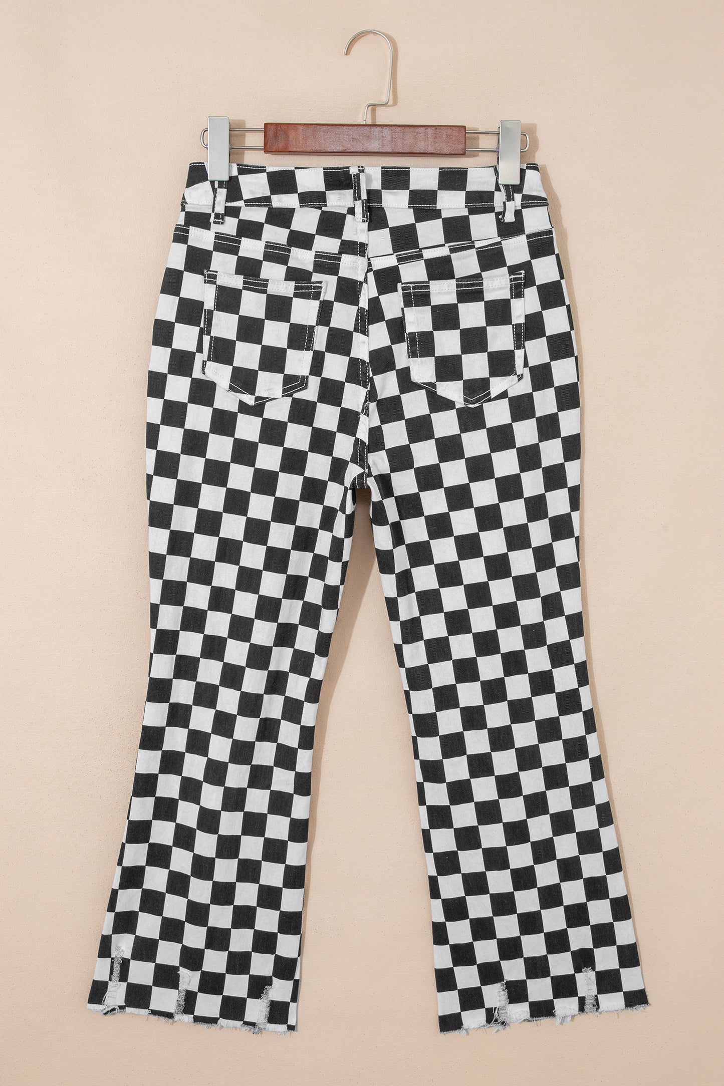 Black checkerboard print distressed raw edge cropped jeans from Lavendar Lane Clothing, featuring holes and a stylish raw hem.