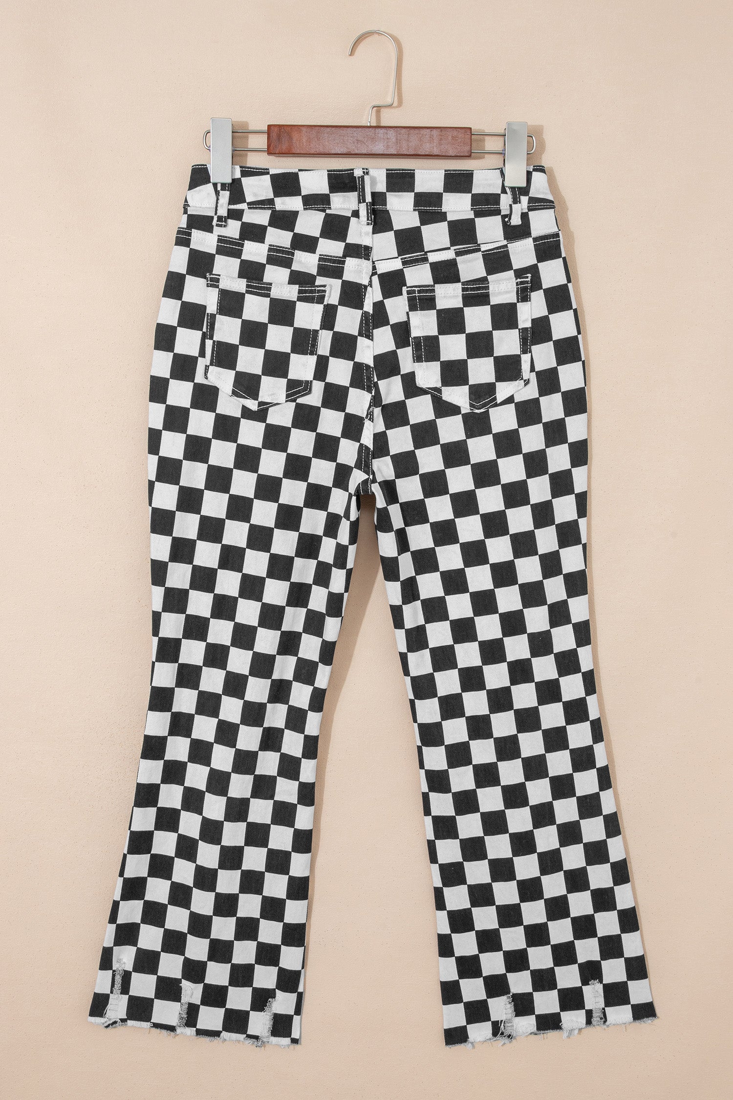 Black checkerboard print distressed raw edge cropped jeans from Lavendar Lane Clothing, featuring holes and a stylish raw hem.