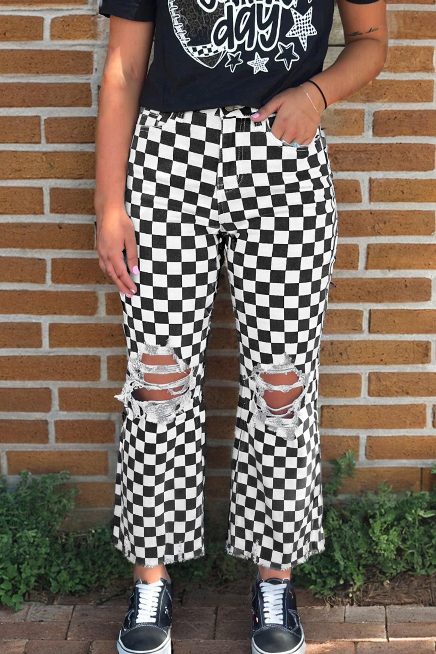 Black checkerboard print distressed raw edge cropped jeans from Lavender Lane Clothing, showing frayed hems and hole details.
