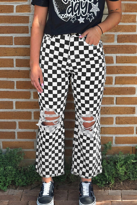 Black checkerboard print distressed raw edge cropped jeans from Lavender Lane Clothing, showing frayed hems and hole details.