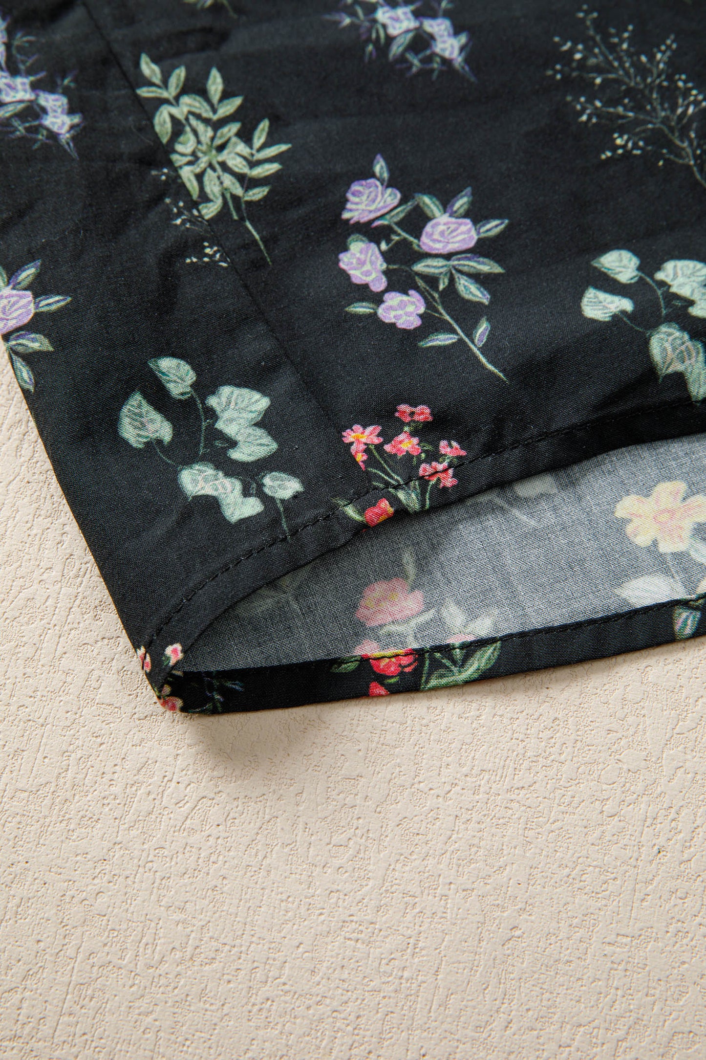 Black floral blouse with frilled trim, short sleeves, and contrast details from Lavendar Lane Clothing, stylish top for casual wear.