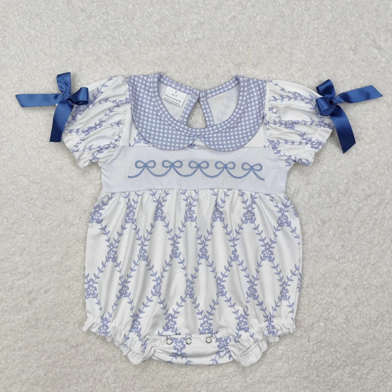 Girl's camo print romper by Lavendar Lane Clothing featuring embroidery, bows, and ruffles.