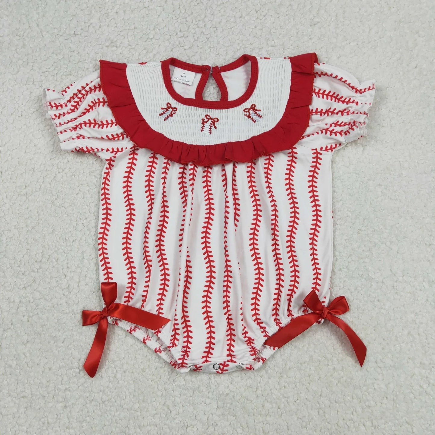 Girl's camo print romper by Lavendar Lane Clothing featuring bows and ruffles, showcasing a playful design for kids.