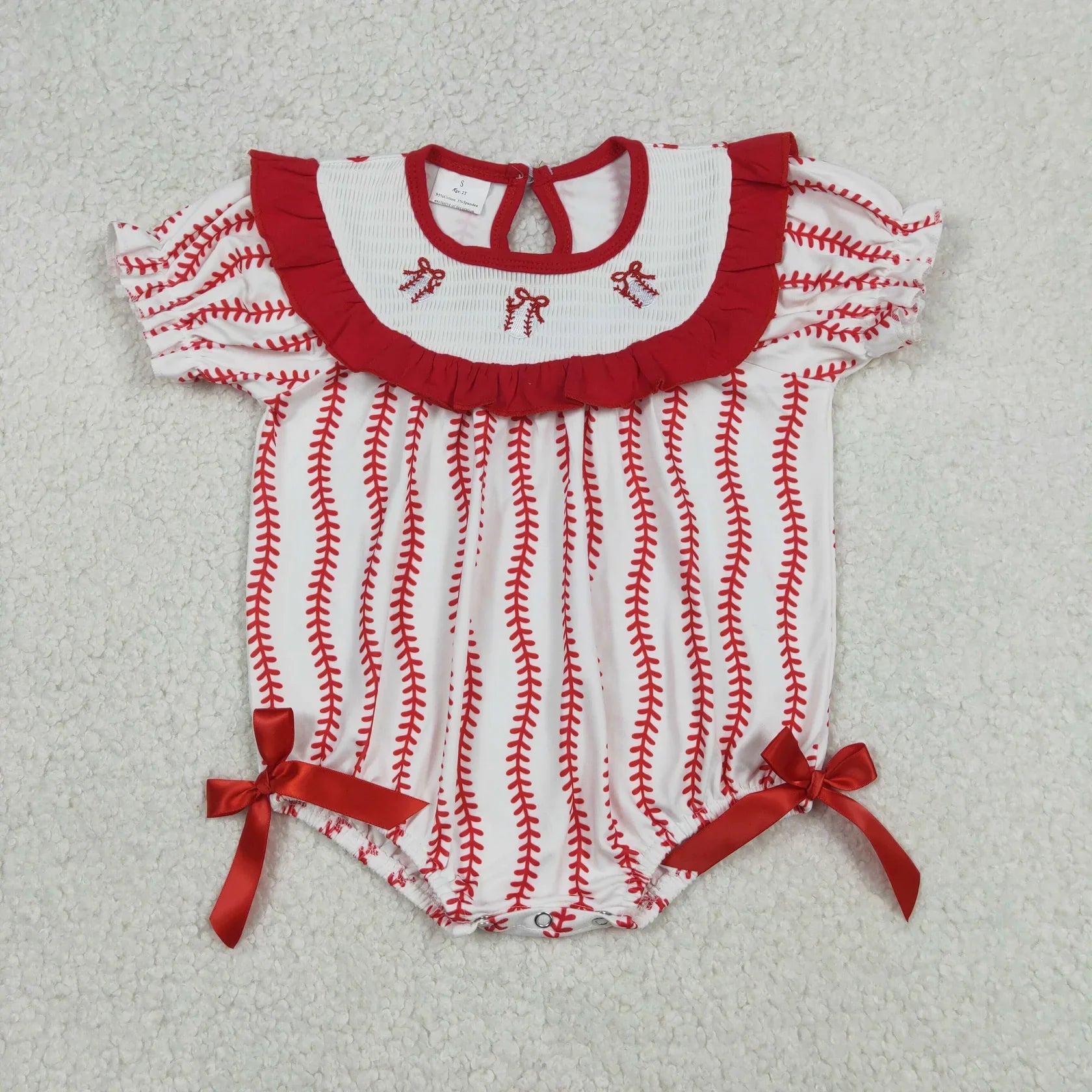Girl's camo print romper by Lavendar Lane Clothing featuring bows and ruffles, showcasing a playful design for kids.