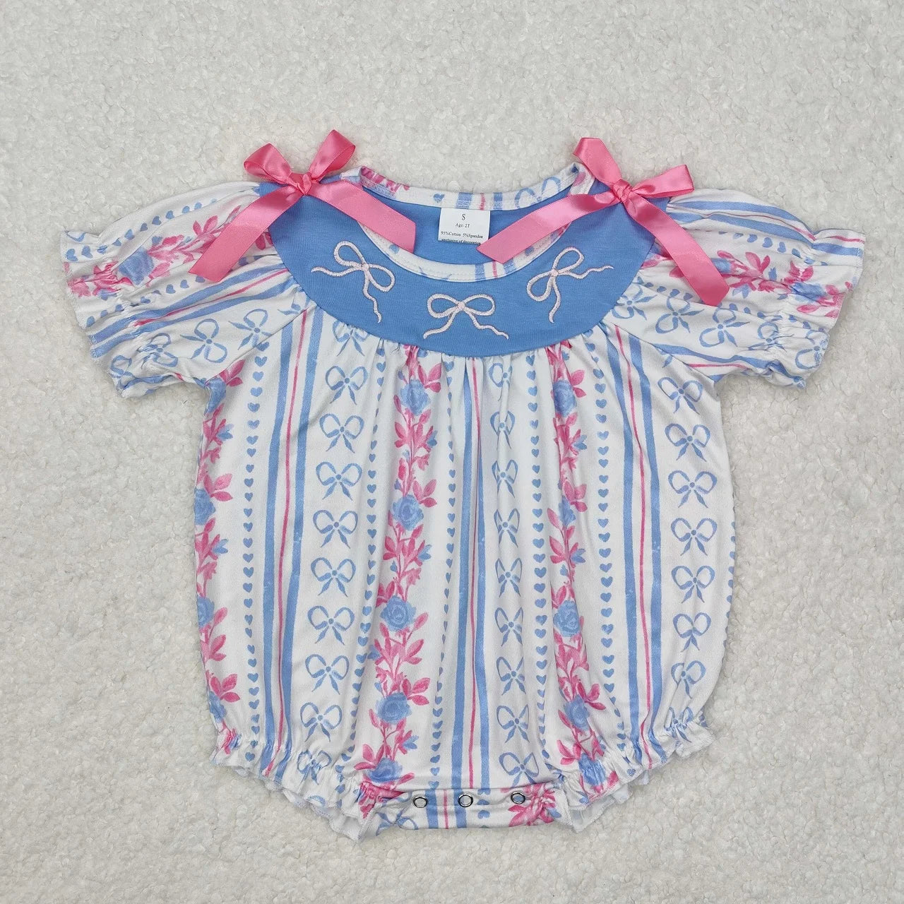 Girl's camo print romper by Lavendar Lane Clothing featuring embroidery, bows, and ruffles.