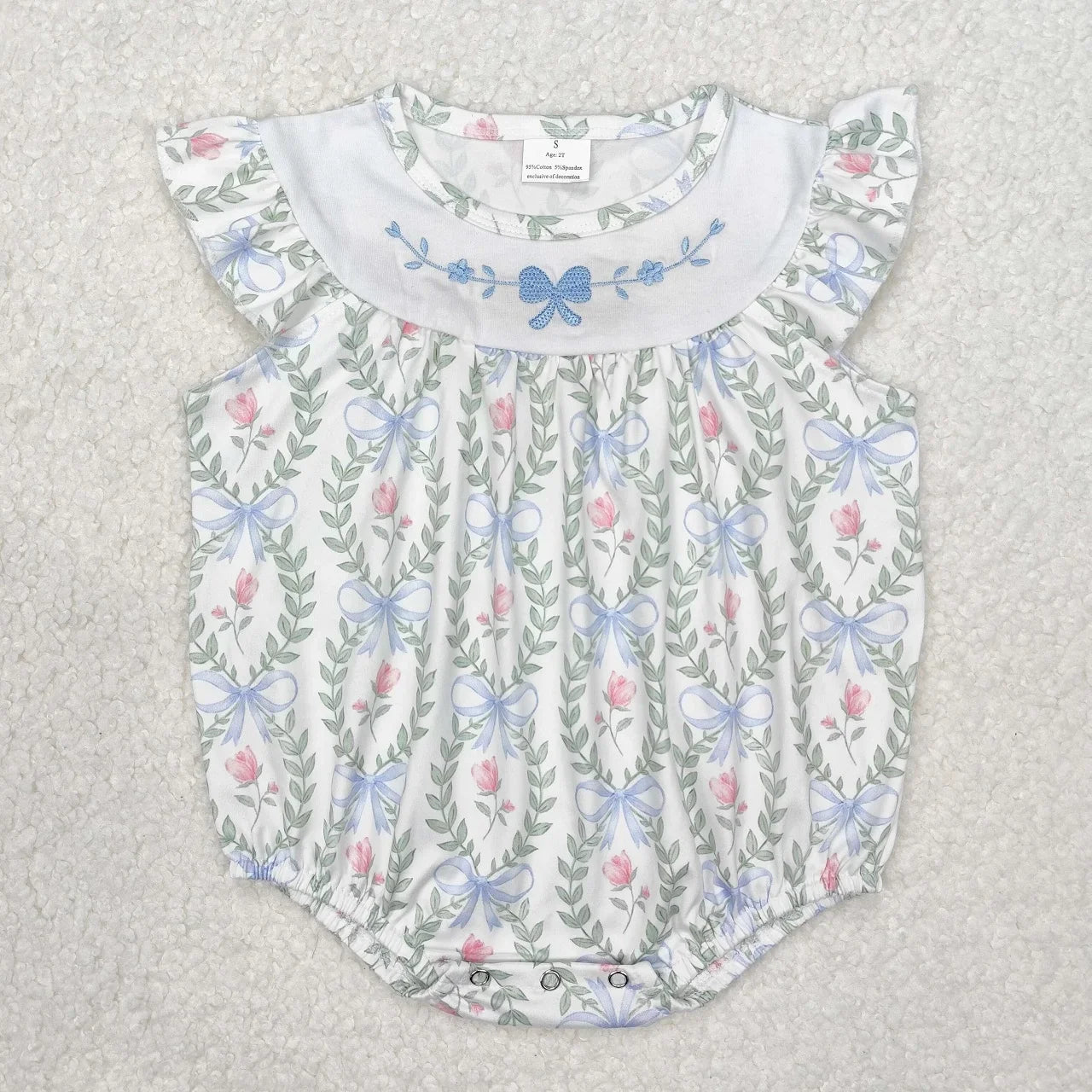 Girl's camo print romper by Lavendar Lane Clothing featuring embroidery, bows, and ruffles for stylish summer wear.