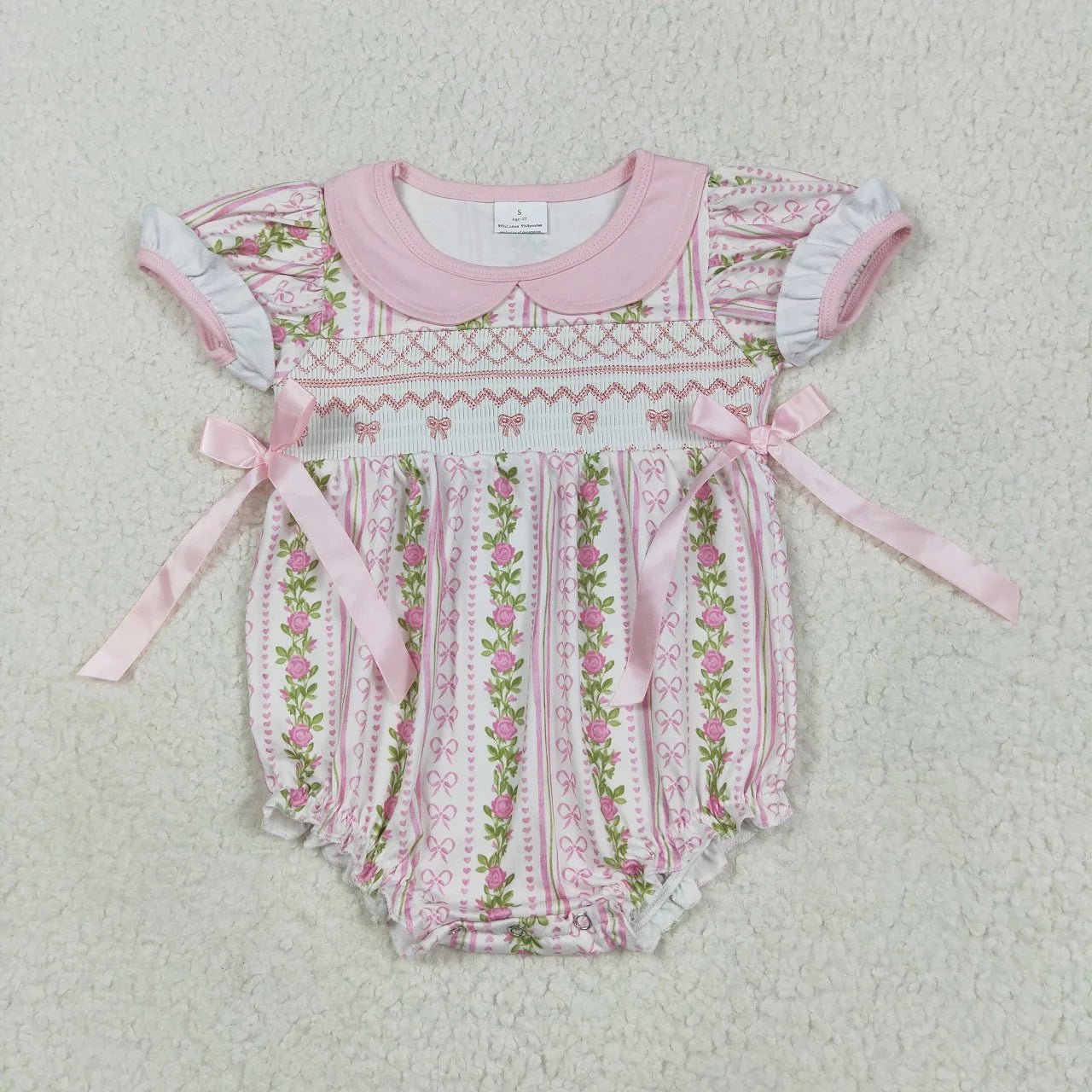 Girl's camo print romper by Lavendar Lane Clothing featuring embroidery, bows, and ruffles.