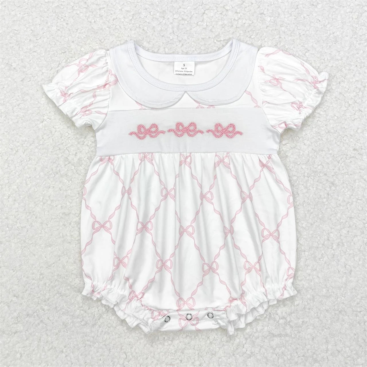 Girl's camo print romper by Lavendar Lane Clothing featuring embroidery, bows, and ruffles.