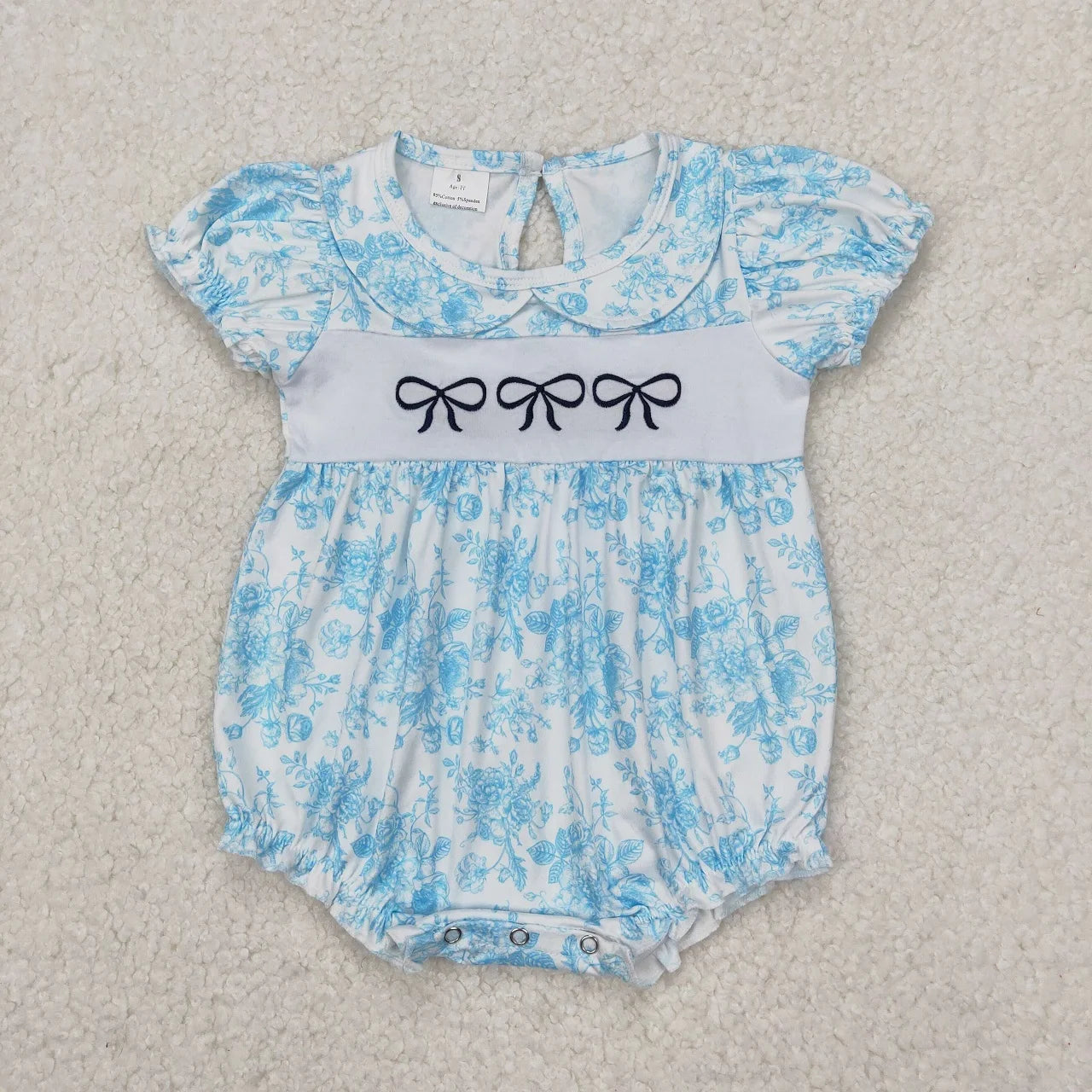 Girl's camo print romper by Lavendar Lane Clothing featuring embroidery, bows, and ruffles.