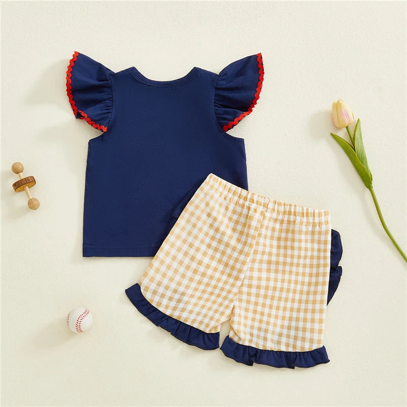 Toddler girl's summer two-piece outfit with embroidered dog tops and plaid shorts from Lavender Lane Clothing.