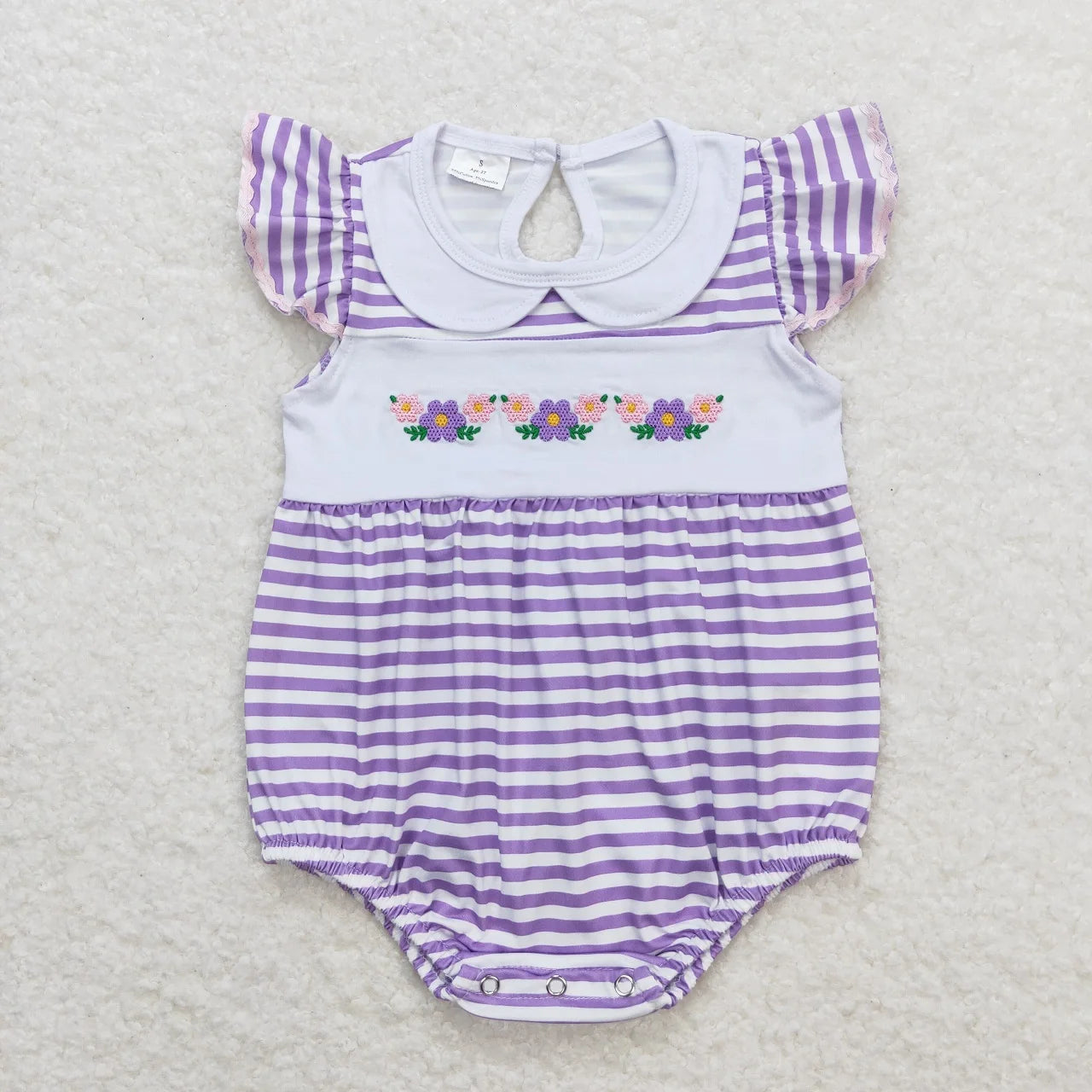 Girl's camo print romper by Lavendar Lane Clothing featuring embroidery, bows, and ruffles for a stylish look.