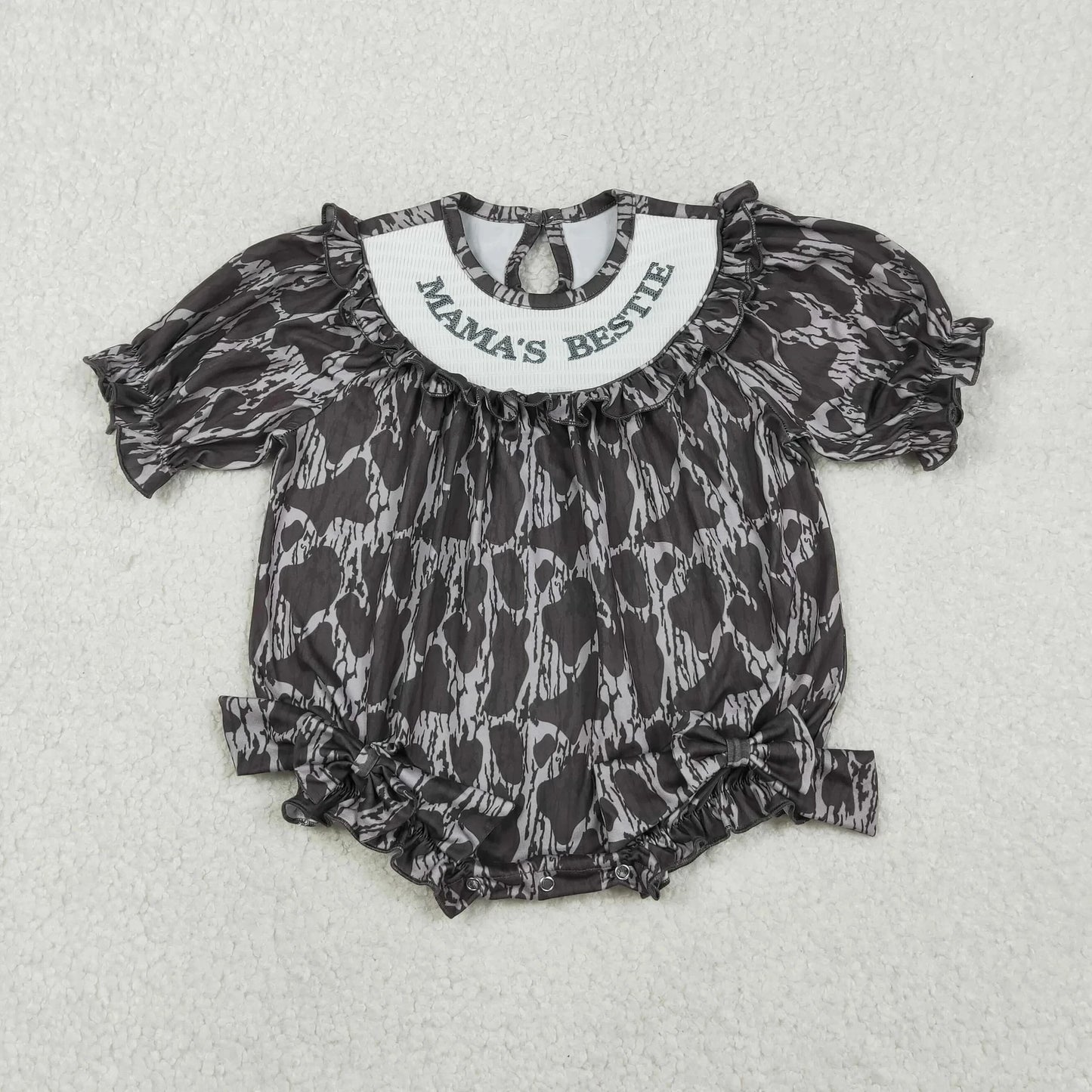 Girl's camo print romper by Lavendar Lane Clothing featuring embroidery, bows, and ruffles.