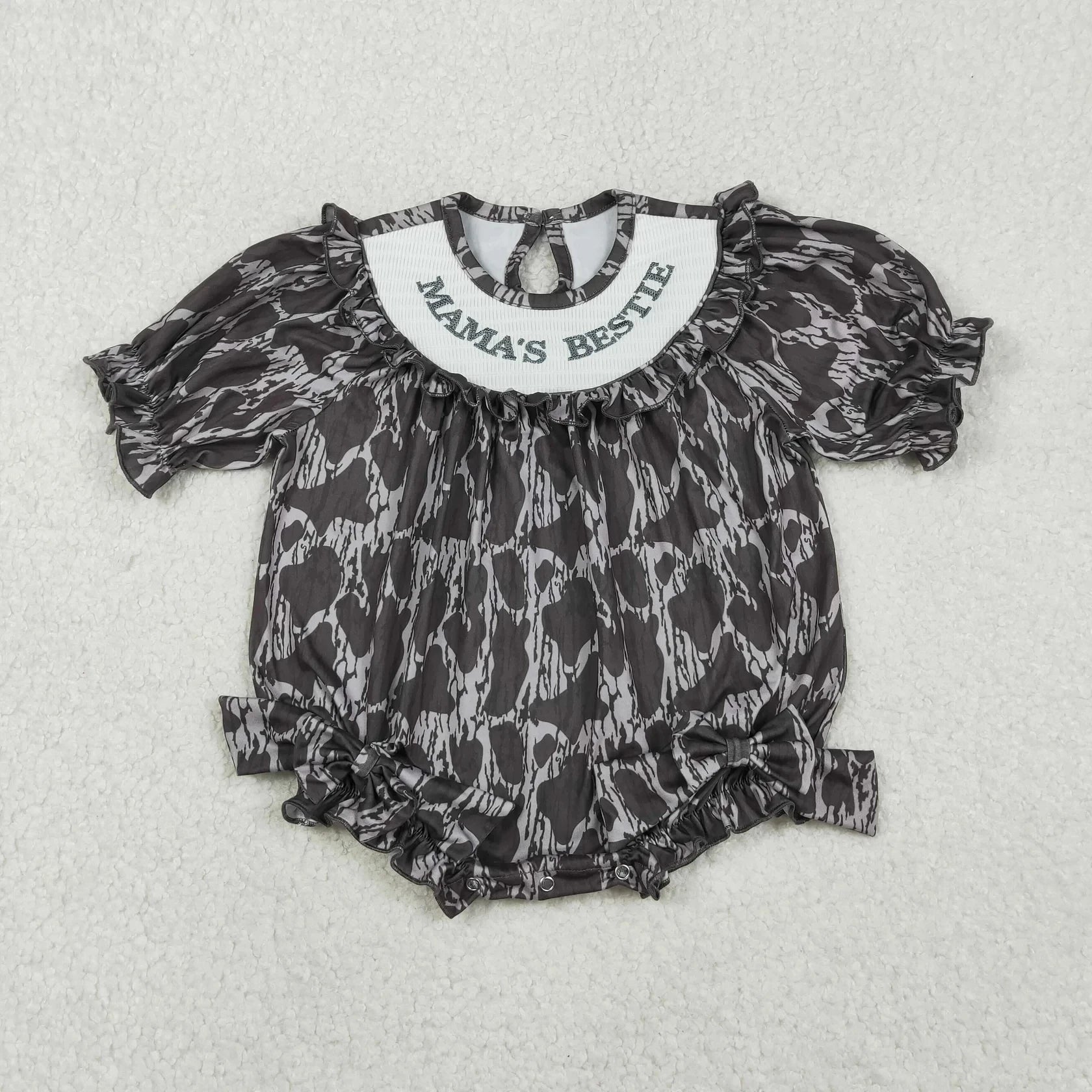Girl's camo print romper by Lavendar Lane Clothing featuring embroidery, bows, and ruffles.