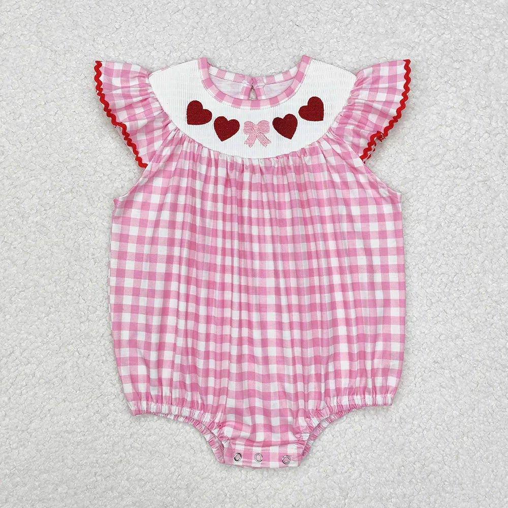 Girl's camo print romper by Lavendar Lane Clothing featuring embroidery, bows, and ruffles. Perfect for playtime.