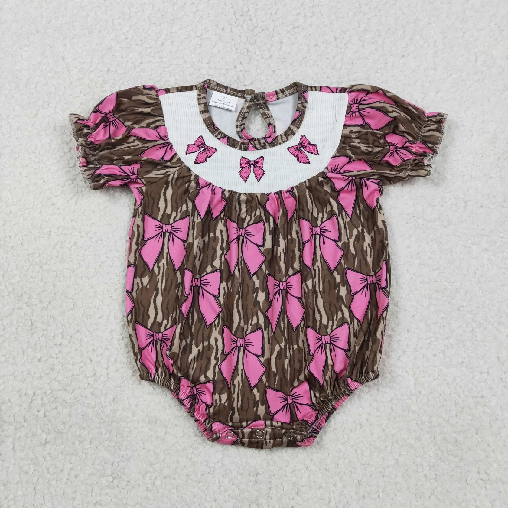 Girl's camo print romper by Lavendar Lane Clothing featuring embroidery, bows, and ruffles.