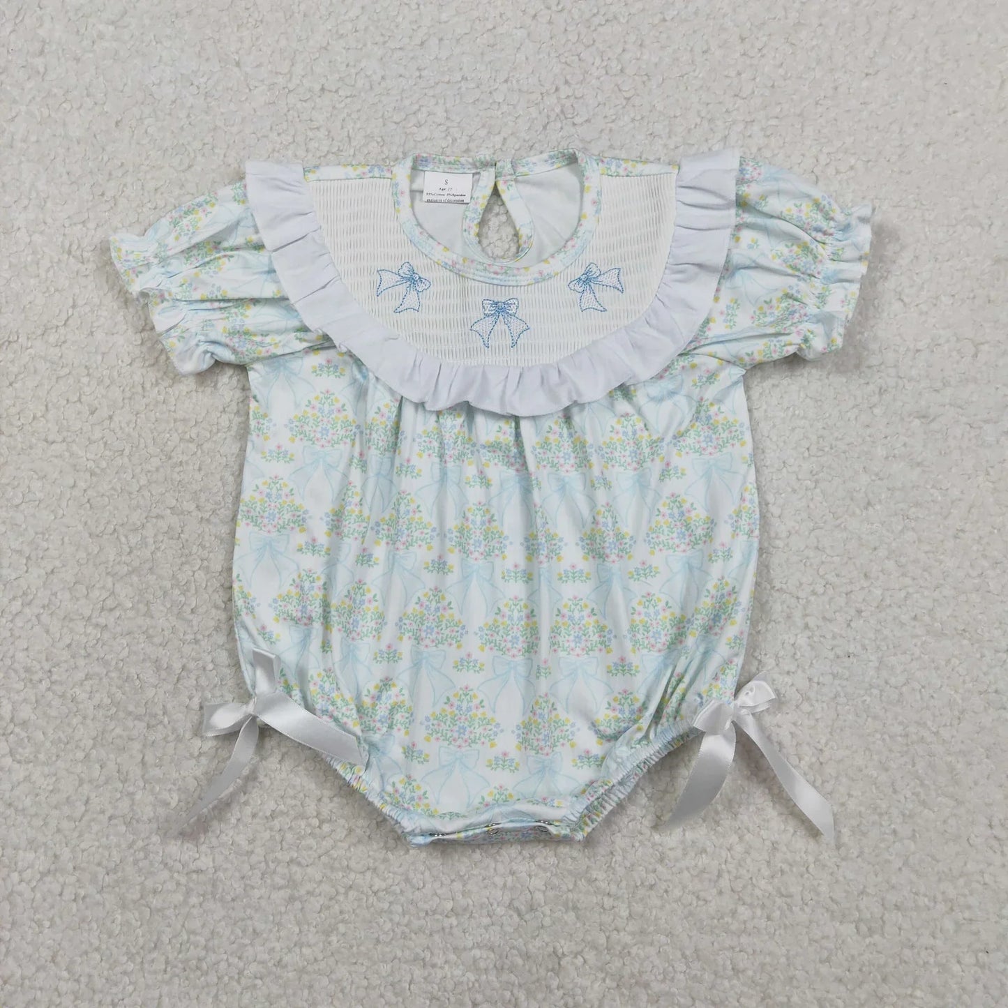 Girl's camo print romper by Lavendar Lane Clothing featuring embroidery, bows, and ruffles.