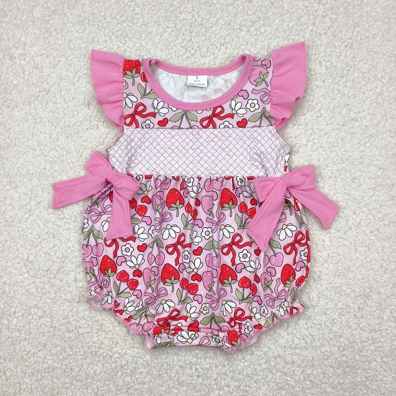 Girl's camo print romper by Lavendar Lane Clothing, featuring embroidery, bows, and ruffles for a playful look.