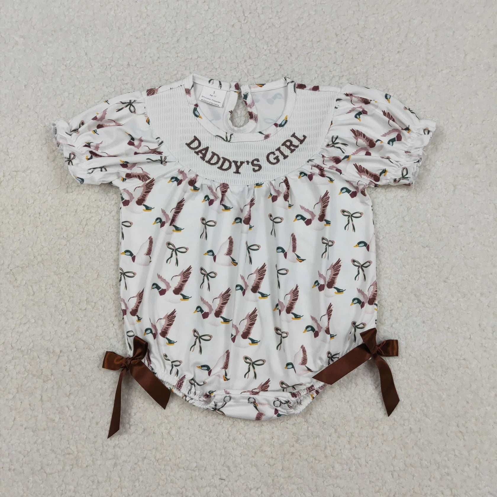 Girl's camo print romper by Lavendar Lane Clothing featuring embroidery, bows, and ruffles.