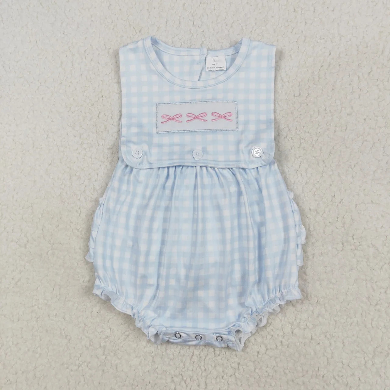 Girl's camo print romper by Lavendar Lane Clothing with bows and ruffles, showcasing a playful and stylish design.