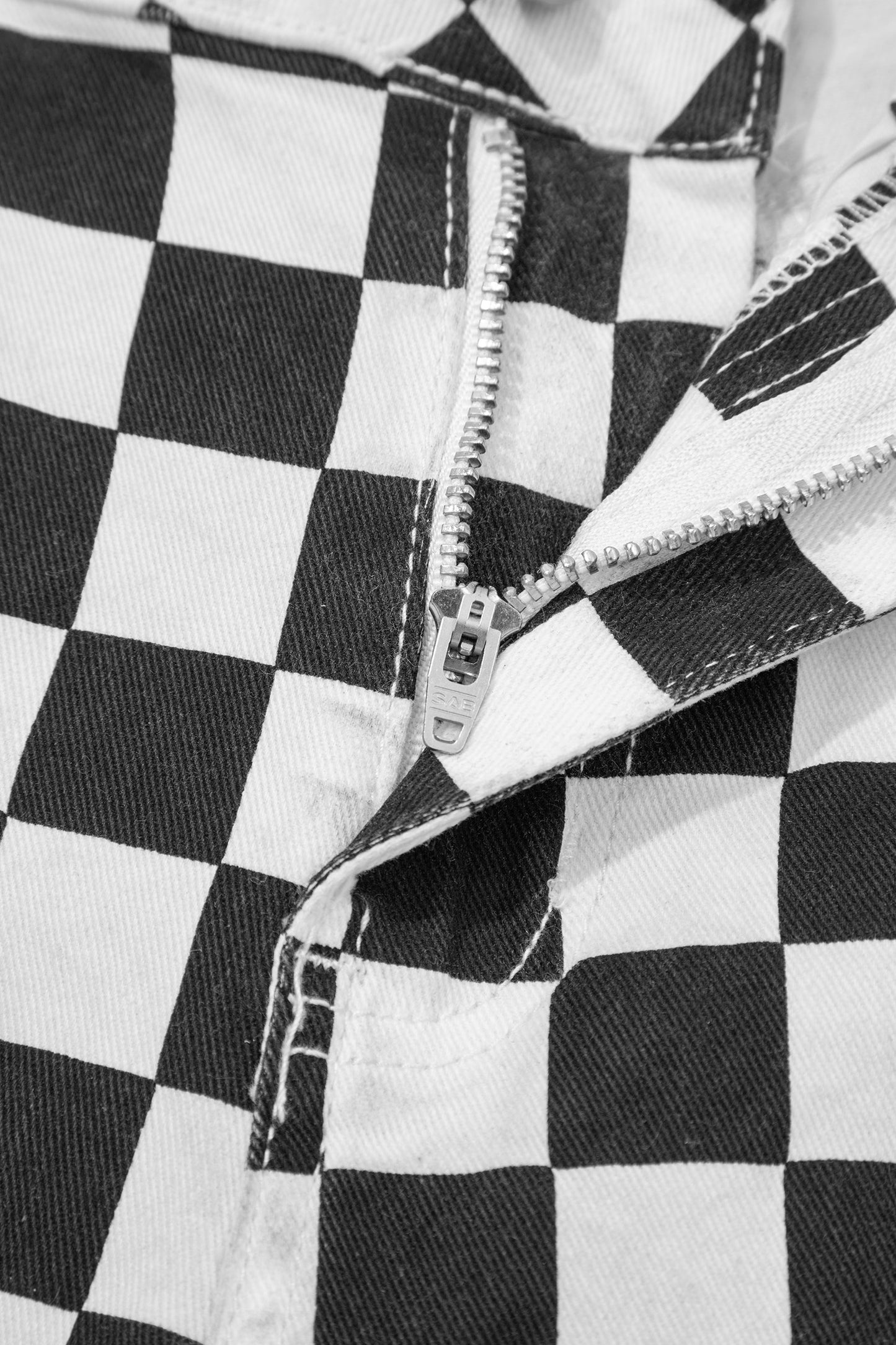 Black checkerboard print distressed cropped jeans with raw edges from Lavendar Lane Clothing, showcasing a trendy, edgy denim style.