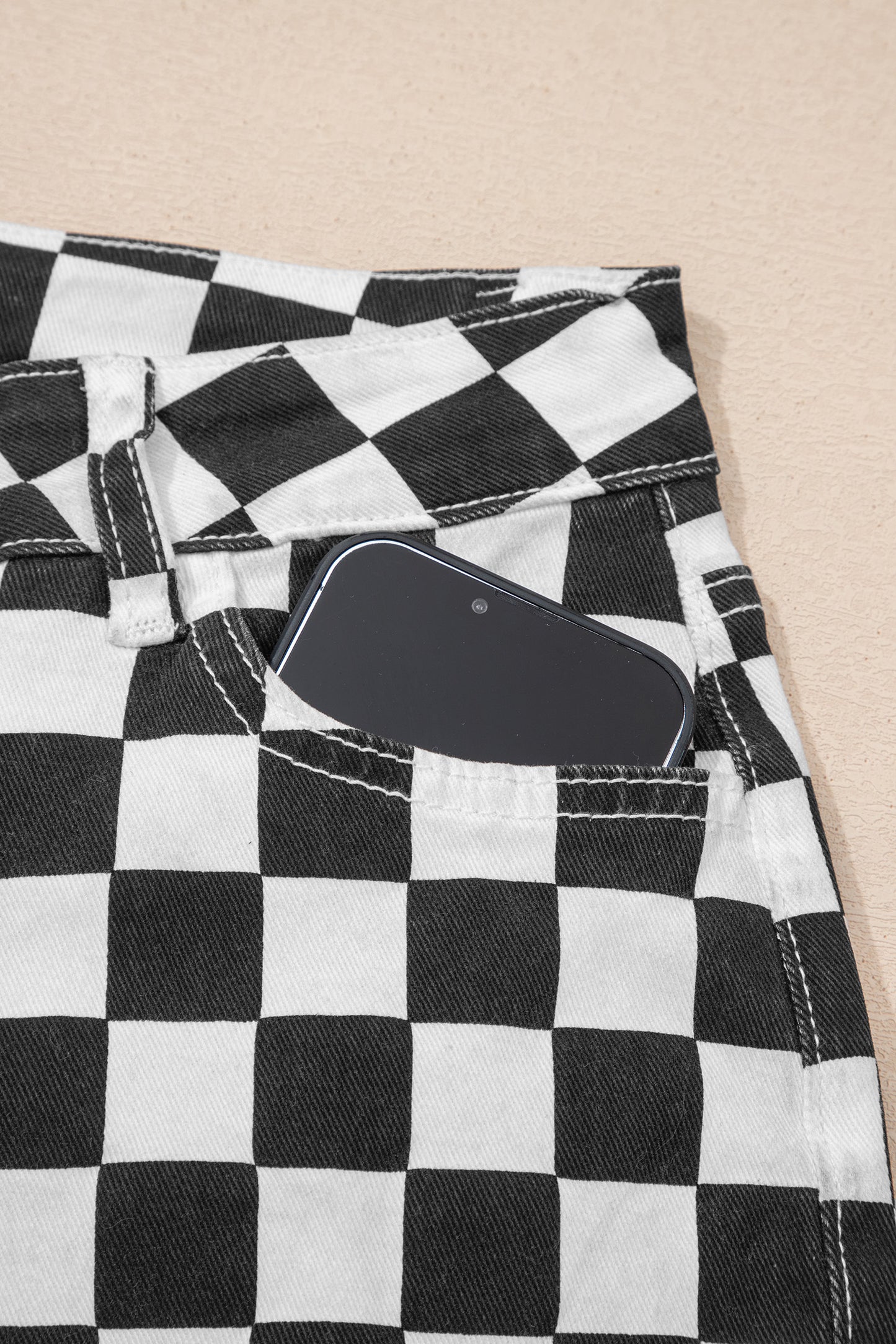 Black checkerboard print distressed raw edge cropped jeans by Lavendar Lane Clothing, featuring holes and a trendy raw hem.