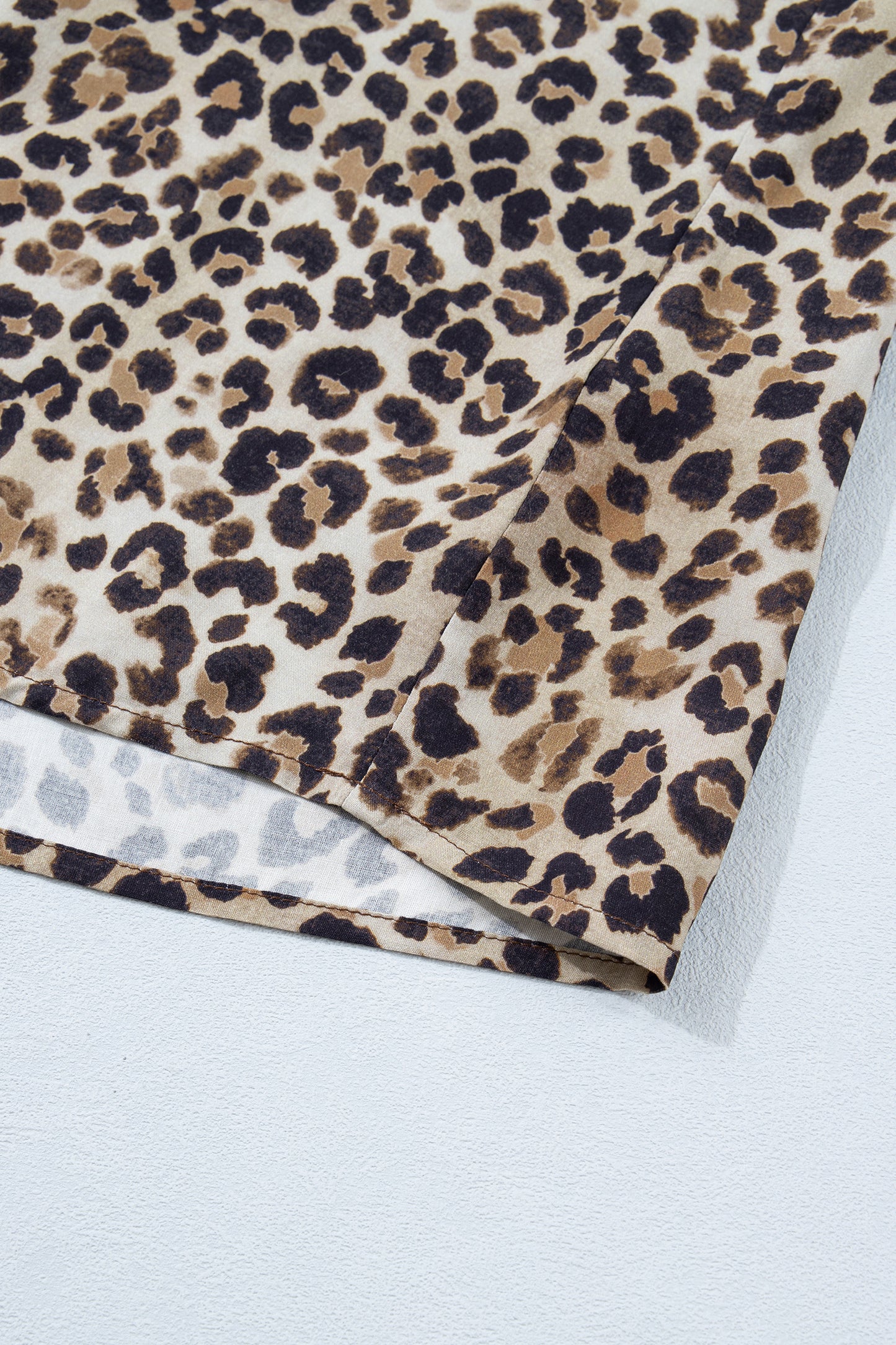 Brown plus size leopard print blouse with crinkled colorblock patchwork and V-neck design by Lavendar Lane Clothing.