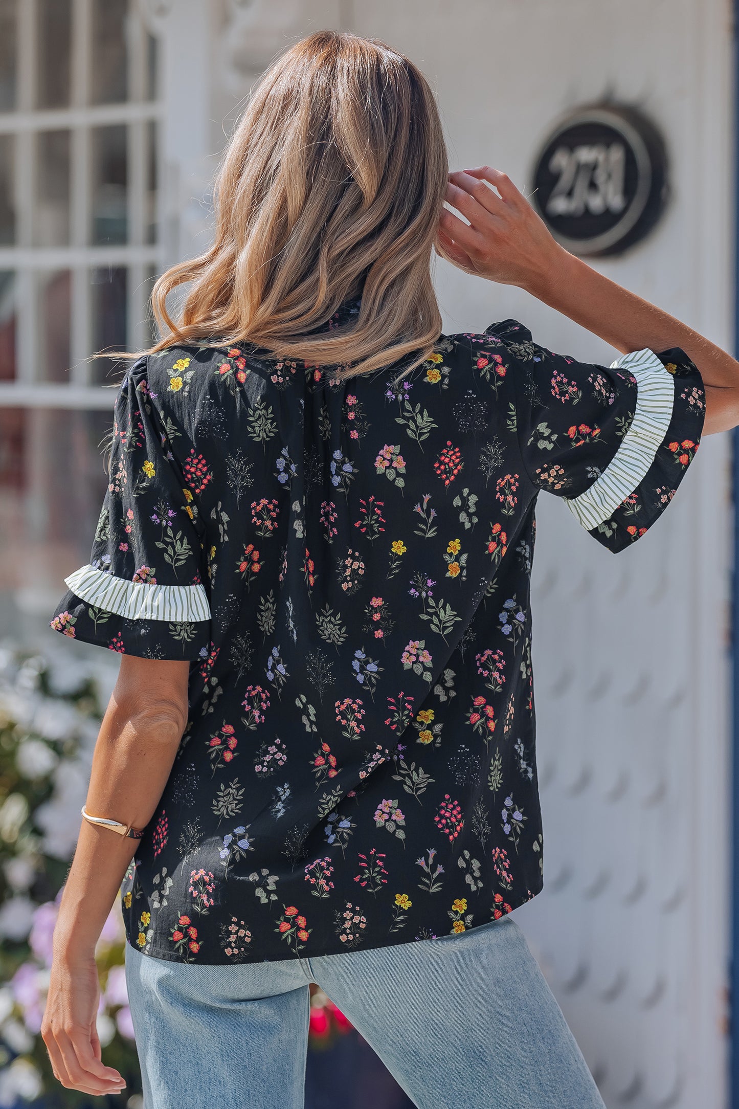 Black floral short sleeve blouse with contrast frilled trim by Lavender Lane Clothing, featuring a stylish and feminine design.