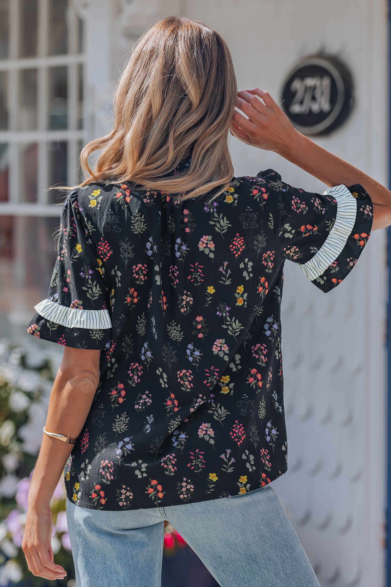 Black floral short sleeve blouse with contrast frilled trim by Lavender Lane Clothing, featuring a stylish and feminine design.