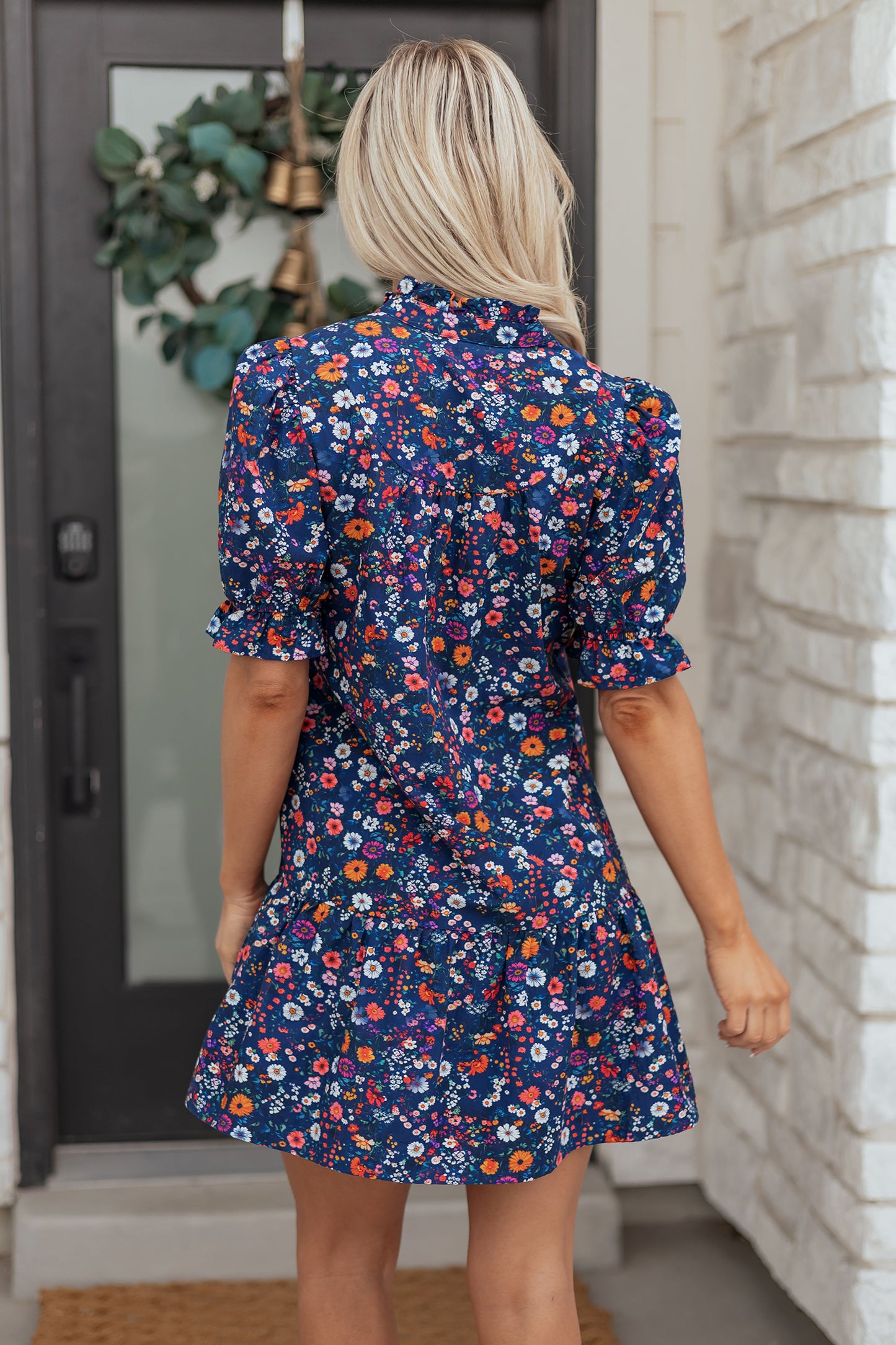 Blue Wild Daisy floral mini dress with split neckline and short puff sleeves by Lavendar Lane Clothing, shown on a model.