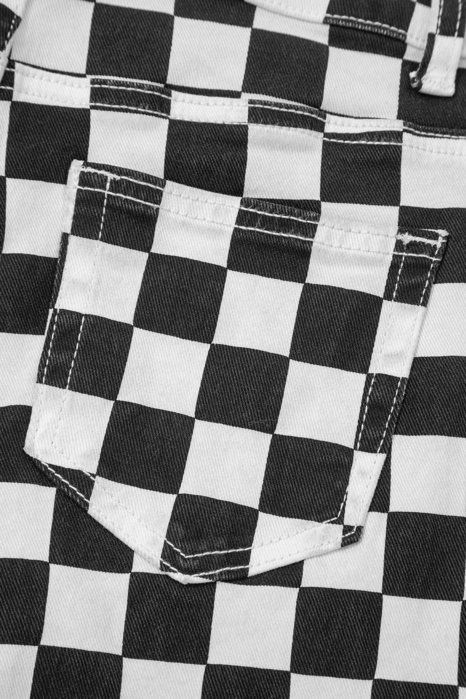 Black checkerboard print distressed raw edge cropped jeans by Lavendar Lane Clothing, showcasing holes and frayed hems.