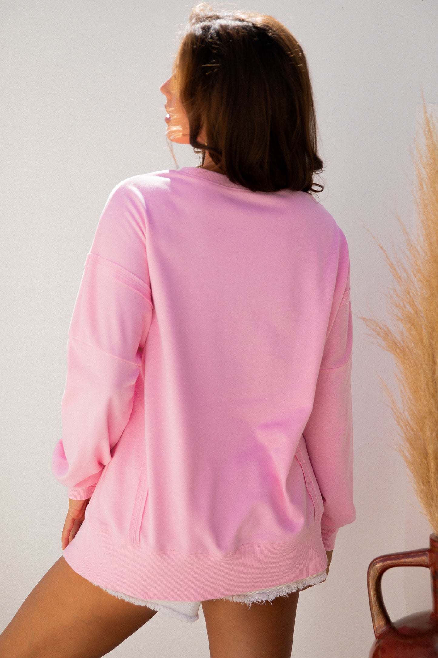 Pink Bow Sequin XOXO letter graphic baggy sweatshirt with exposed seams from Lavendar Lane Clothing, casual and stylish blouse.