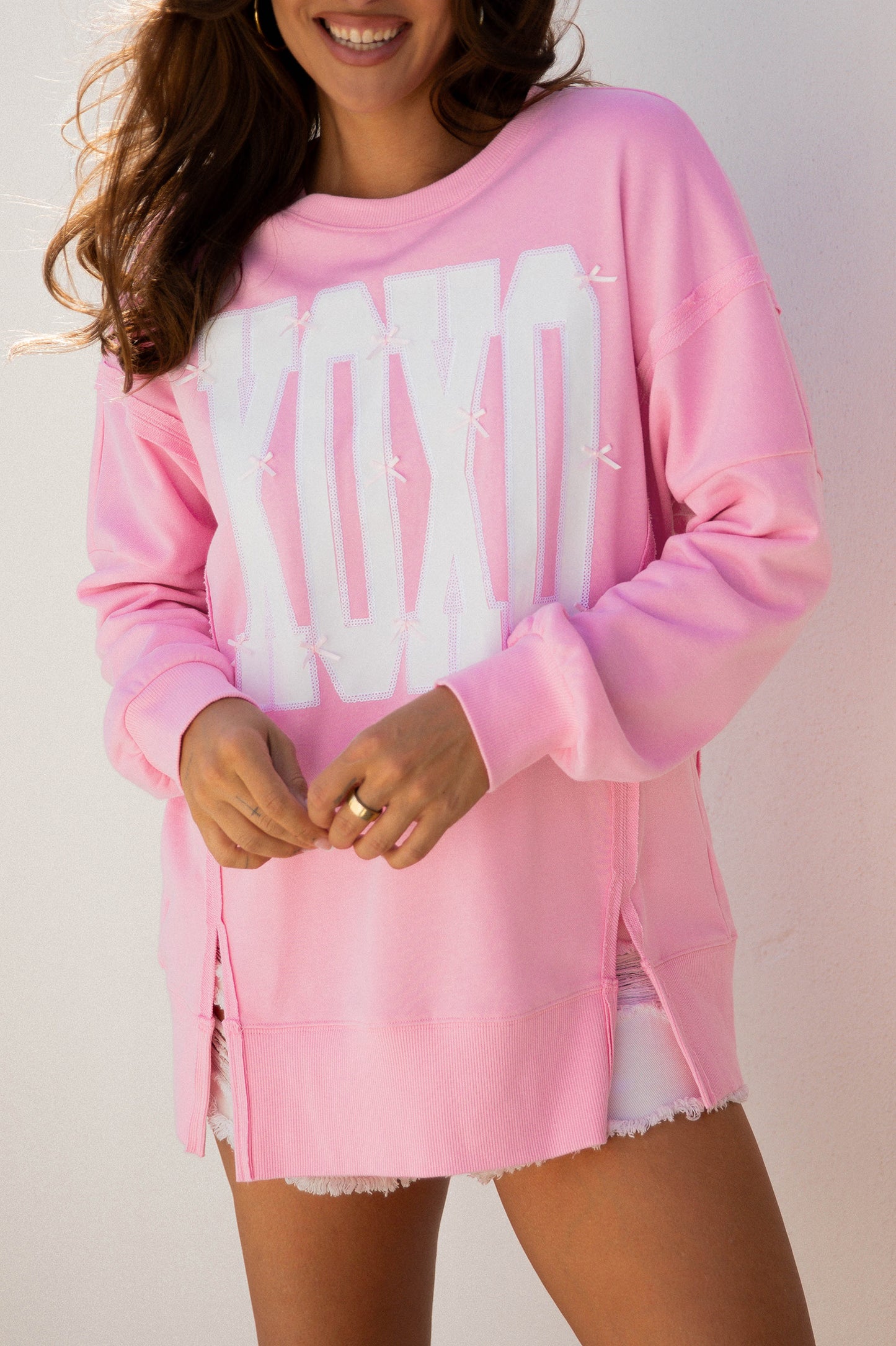 Pink sequin XOXO letter graphic baggy sweatshirt with exposed seams, stylish blouse from Lavendar Lane Clothing.